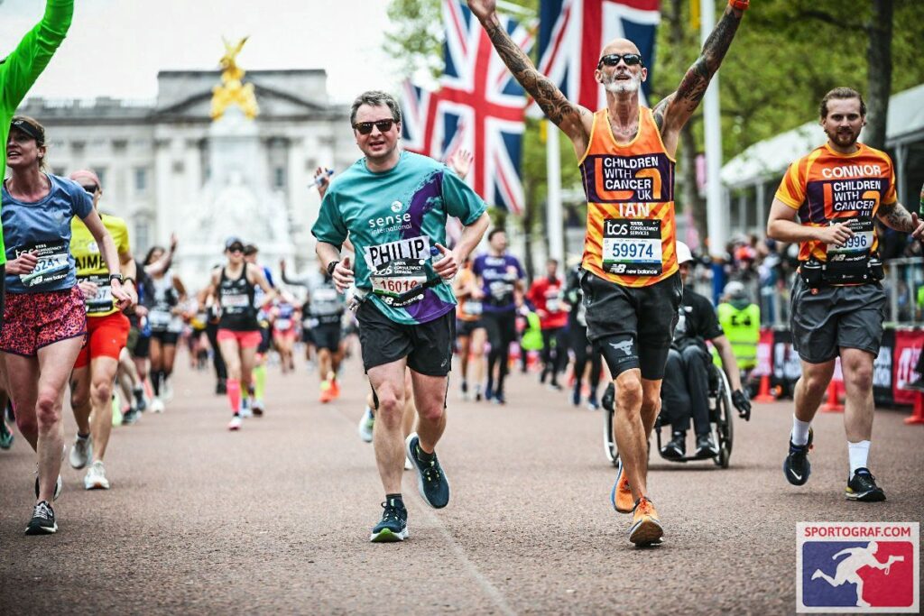 A man running up The Mall at the London Marathon in a Sense International vest.