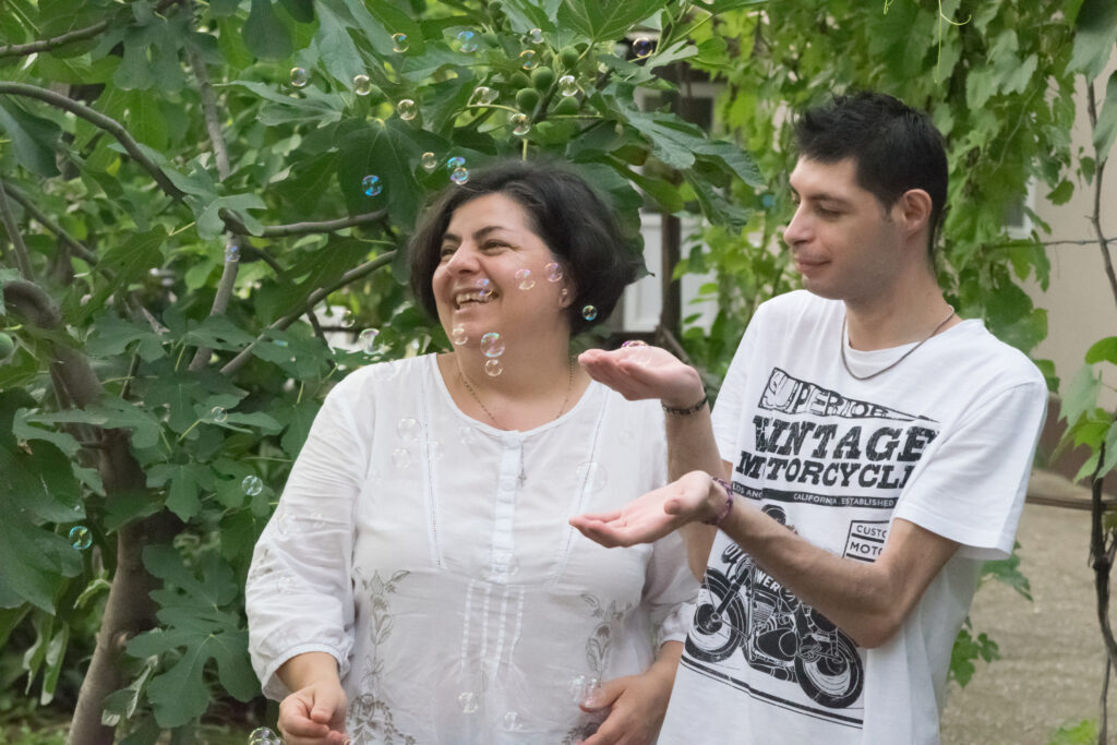 A man and a woman woaling in a garden