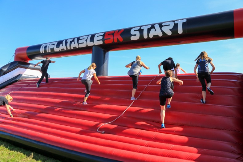 People running up an inflatable obstacle