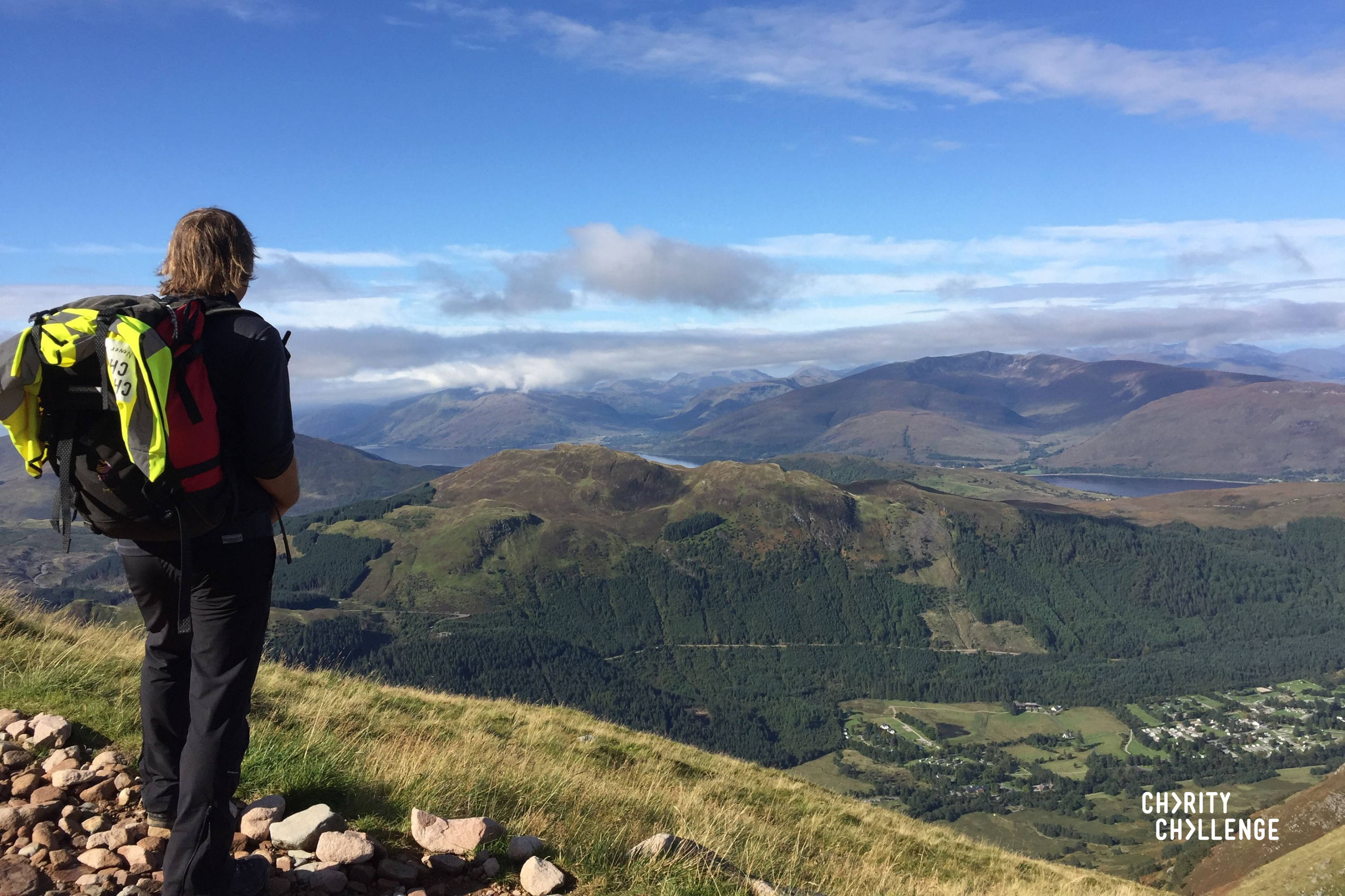 A walker wearing a backpack looking at the landscape.