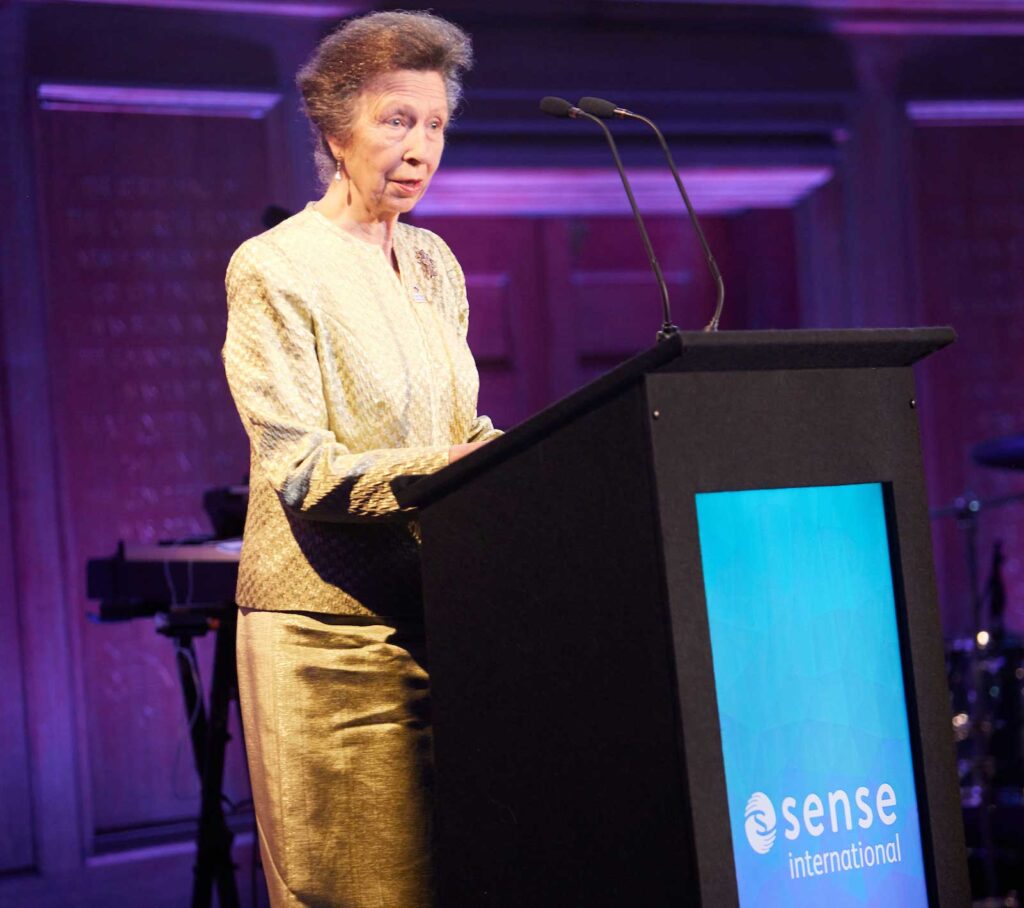 Our Patron, HRH The Princess Royal, speaks in front of a lectern showing the Sense International logo