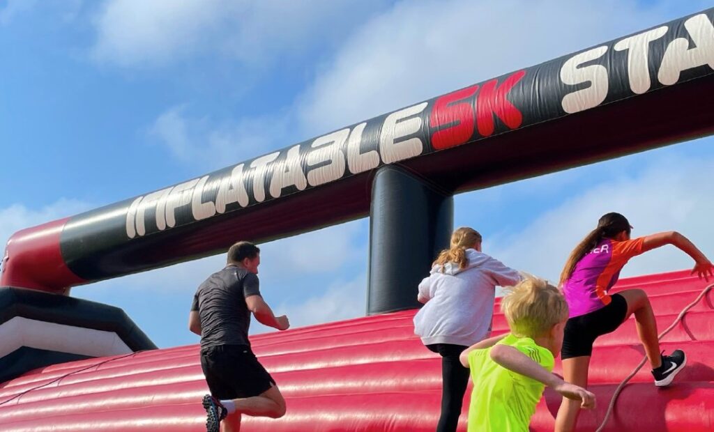 People running up an inflatable obstacle. 